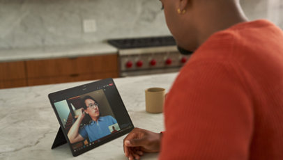 A person joins a Teams video call while standing in his kitchen. 