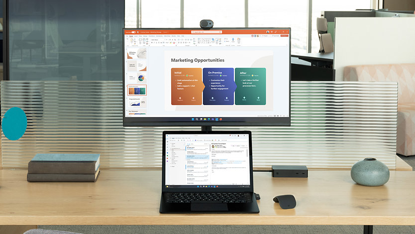 Surface Laptop 5 voor zakelijk gebruik met Windows 11 op het scherm, op een bureau met een monitor. 