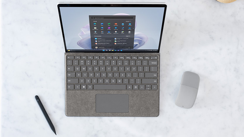Une Surface Pro 9 pour les entreprises affichant Windows 11 avec un clavier Type Cover, un souris Surface Arc Mouse et un stylet Surface Slim Pen.