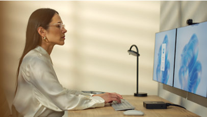 Una donna seduta alla sua scrivania accede a Windows 365.