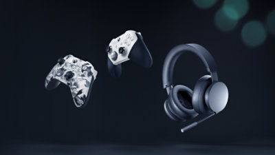 A black Xbox wireless headset and two Xbox wireless controllers in White Elite and Storm Breaker. 