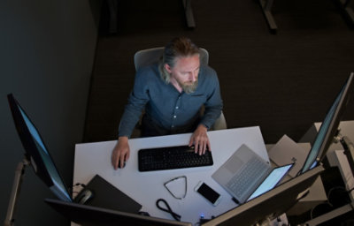 An overhead view of a man working at a desk.