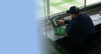 Person seated at a workstation using a computer and equipment in an indoor workspace.
