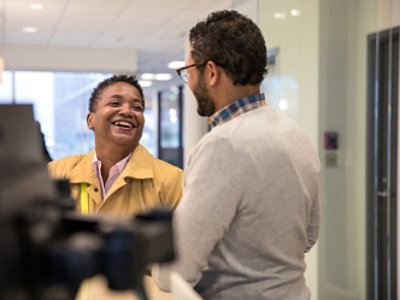 A man and woman smiling at each other in an office.
