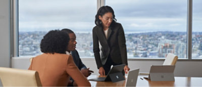 A group of business people in a meeting room with a view of the city.