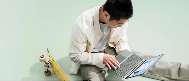 Ein Mann sitzt und arbeitet an seinem Laptop