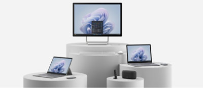 A desktop all in one, a laptop, a tablet and a speaker with remote placed on the various round tables