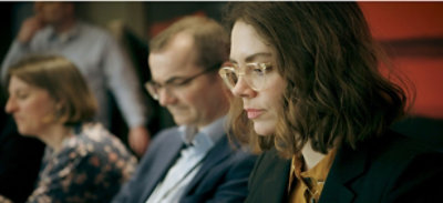 Un grupo de personas sentadas en una sala de conferencias.