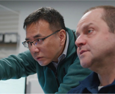 Two persons looking into the screen