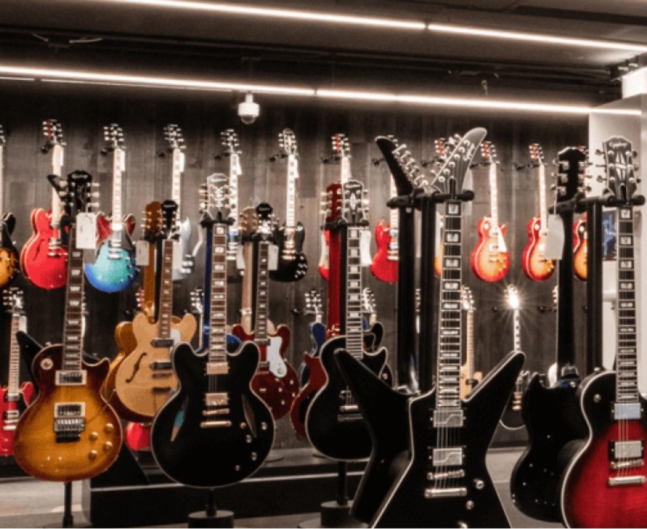 Many guitars are on display in a store.
