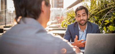 Two professionals collaborating at an outdoor workspace.