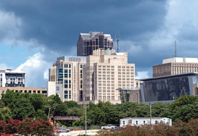 City skyline with modern office buildings beneath dark, cloudy skies.