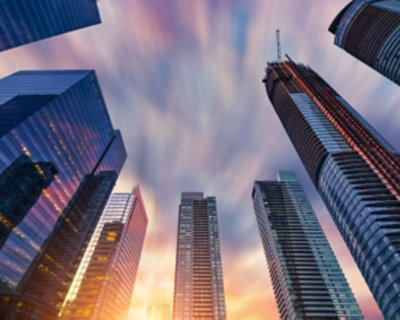Skyline of modern skyscrapers under a colorful sky with dynamic cloud motion during sunset.