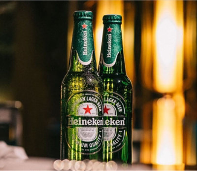 Twee flesjes Heineken die op een tafel staan.