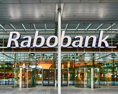 Exterior view of a rabobank building with glass doors and a large sign displaying the bank's name above the entrance.