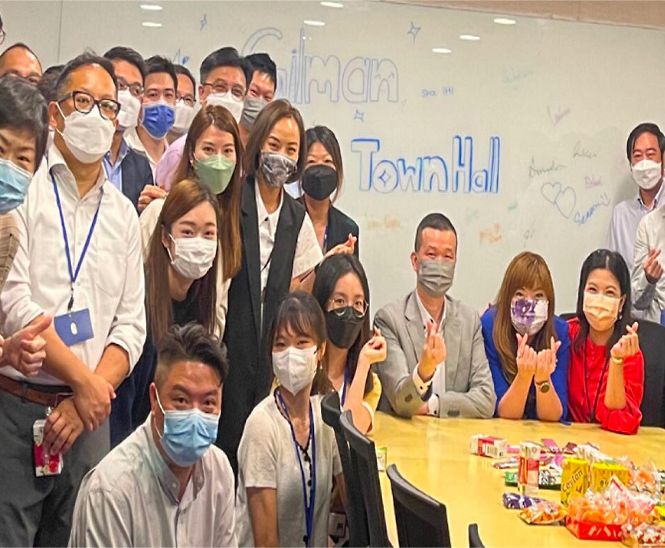 Um grupo de pessoas posando para uma foto usando máscaras de rosto.