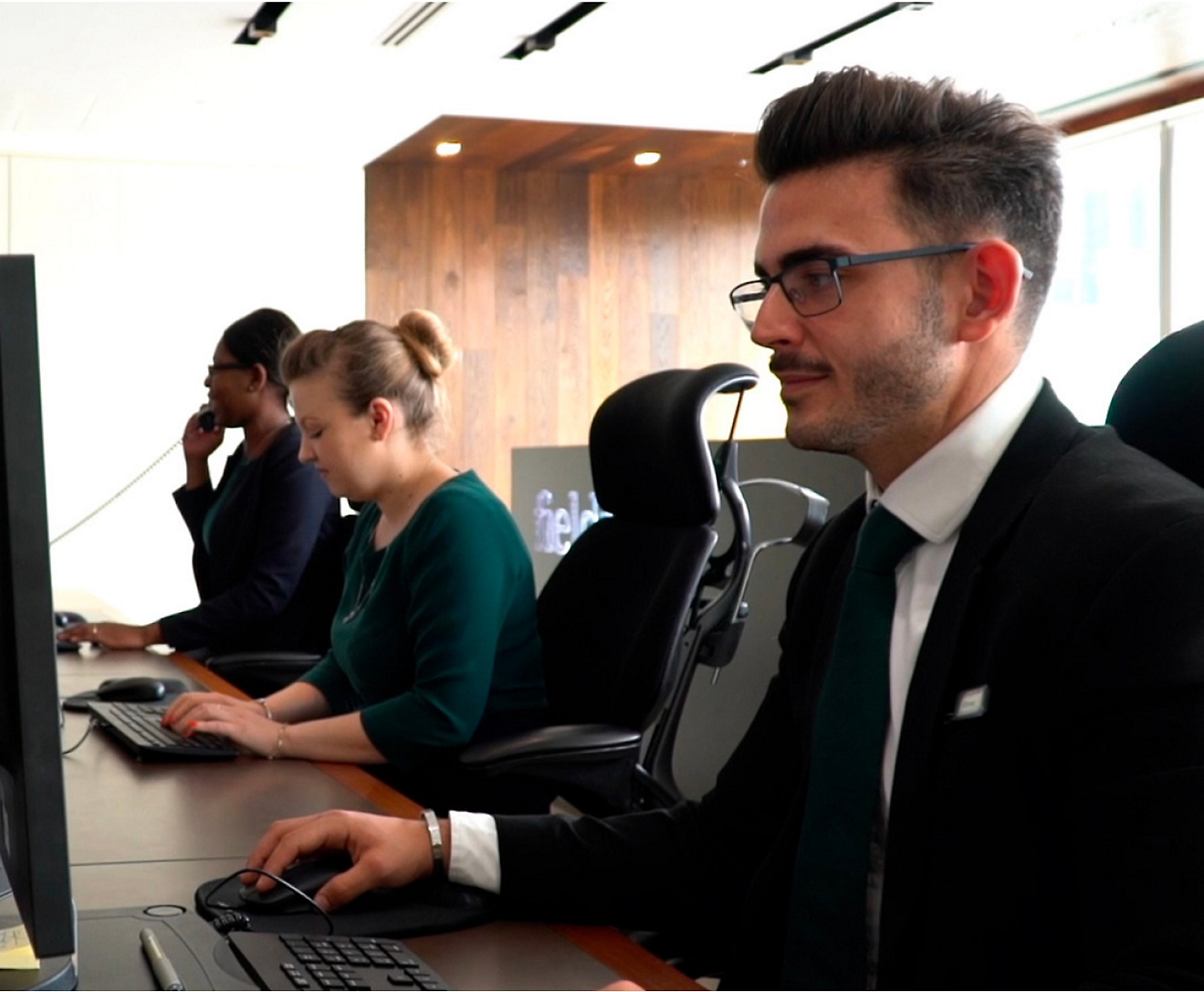 Um grupo de pessoas trabalhando em computadores em um escritório.