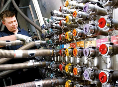 A man is working on a machine with many different colored hoses.