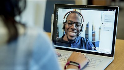 Um homem e uma mulher estão em uma videochamada em um laptop.