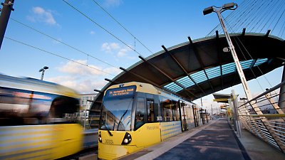 Een gele en zwarte trein stopt op een station.