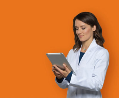 A person in a white coat holding a tablet