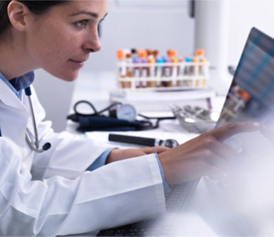 A Doctor in a white coat using a computer