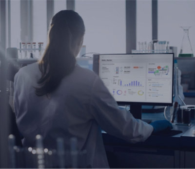 A person in a lab coat working on a computer
