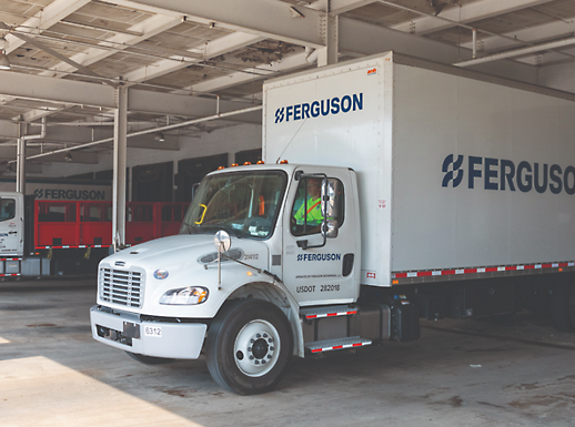 Bílé nákladní auto společnosti Ferguson je ve skladišti