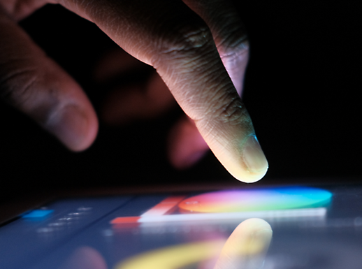A close-up of a finger touching a touchscreen