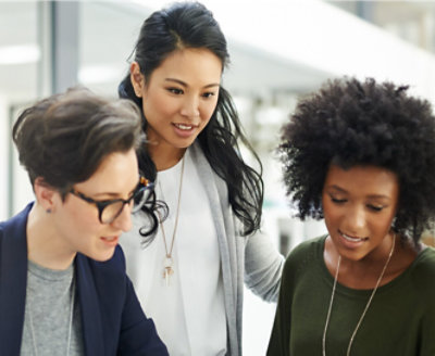 Three women looking at a computer screen.
