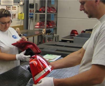 Twee personen die de achterlichten van een auto controleren