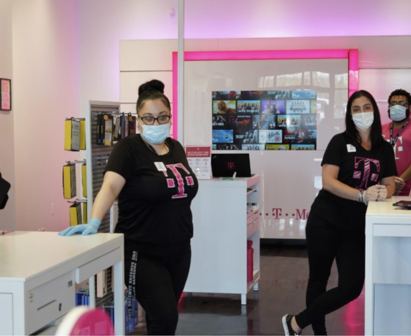 Grupa osób z maskami na twarzach w sklepie.