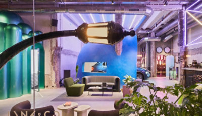 Een kamer met een neonlamp en een bank.