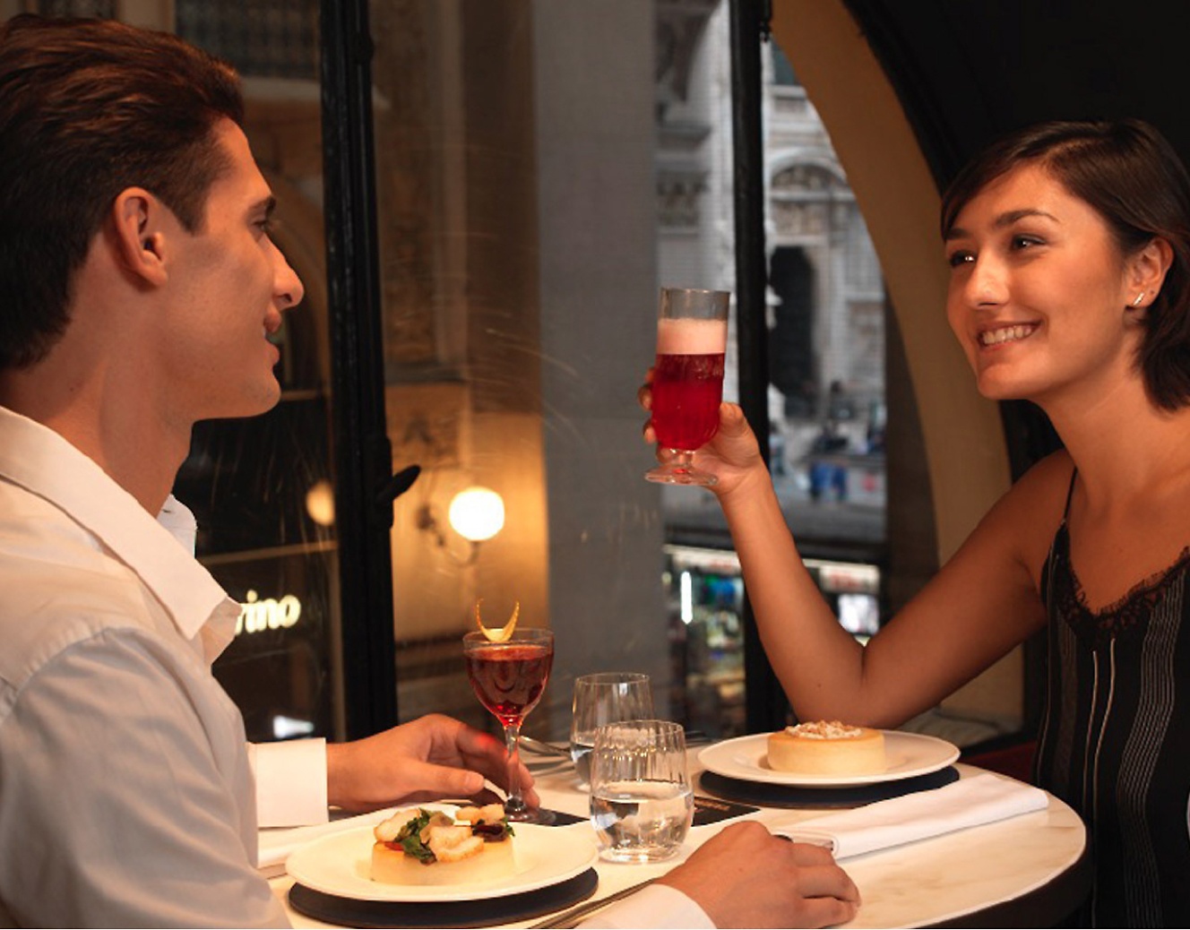 Homem e uma mulher tomando drinks durante o jantar
