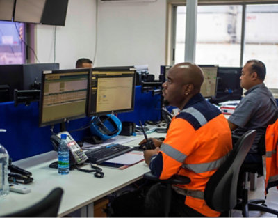 Dos personas con pantalones de seguridad trabajando en un escritorio