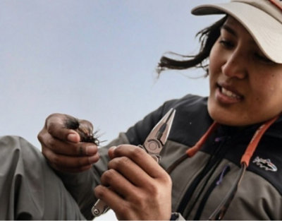 A woman wearing a hat working with tools
