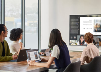 A group of people sitting at a table with laptops