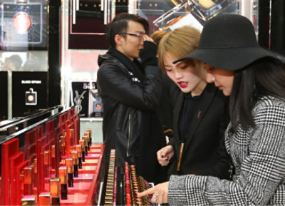 A group of people looking at lipstick