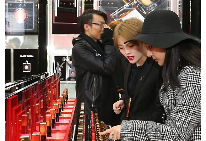 A group of people looking at lipstick