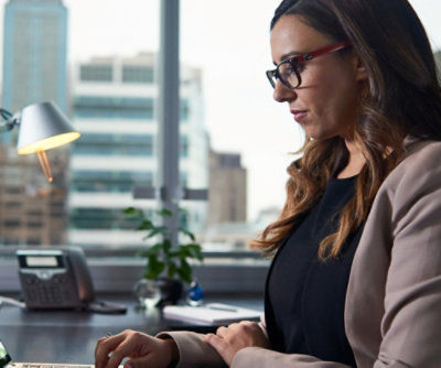 A person in glasses looking at a computer