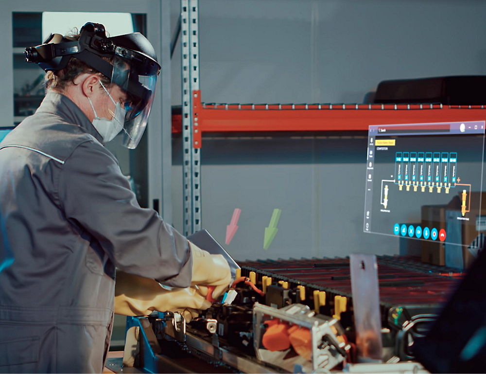 Ein Techniker mit Schutzkleidung und Gesichtsmaske arbeitet an einer Maschine, während er Daten auf einem Bildschirm in einer industriellen Umgebung überwacht.
