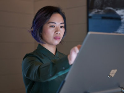 A person wearing a green shirt using a computer.