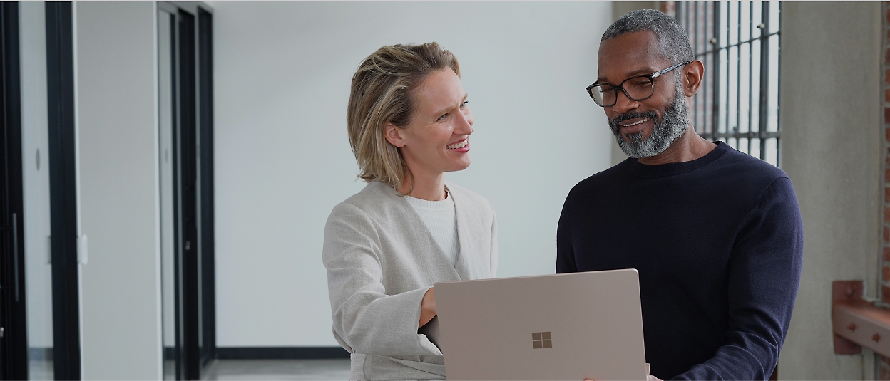 Microsoft Surface 노트북을 들고 있는 남성과 여성.