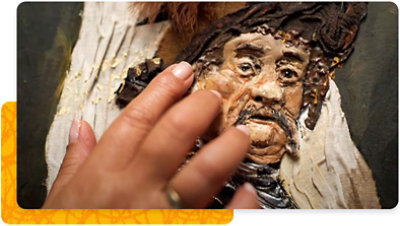 A person experiences a painting by touching it