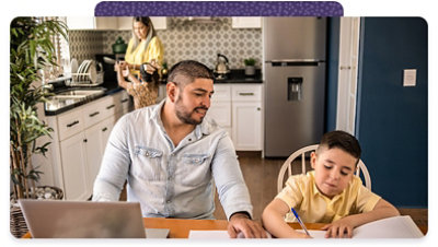 A man and a boy work together at a kitchen table. 
