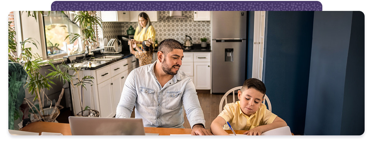 A man and a boy work together at a kitchen table.