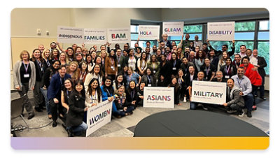 A large group of employees gather with signs representing their Employee Resource Groups.