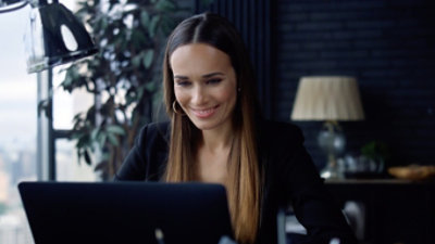 A woman sitting at a desk with a laptop in front of her.