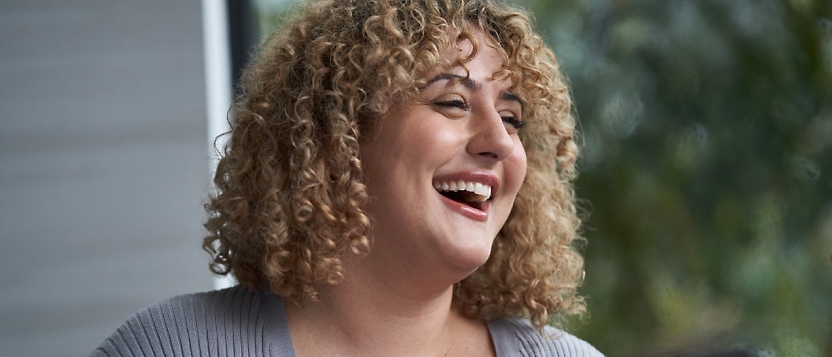 A smiling woman with curly hair.