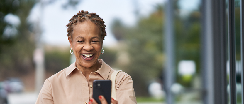 A person smiling while holding a phone